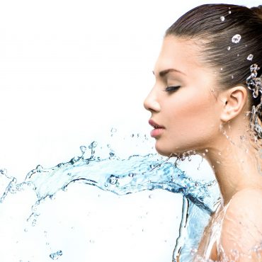 Beautiful model woman with splashes of water in her hands